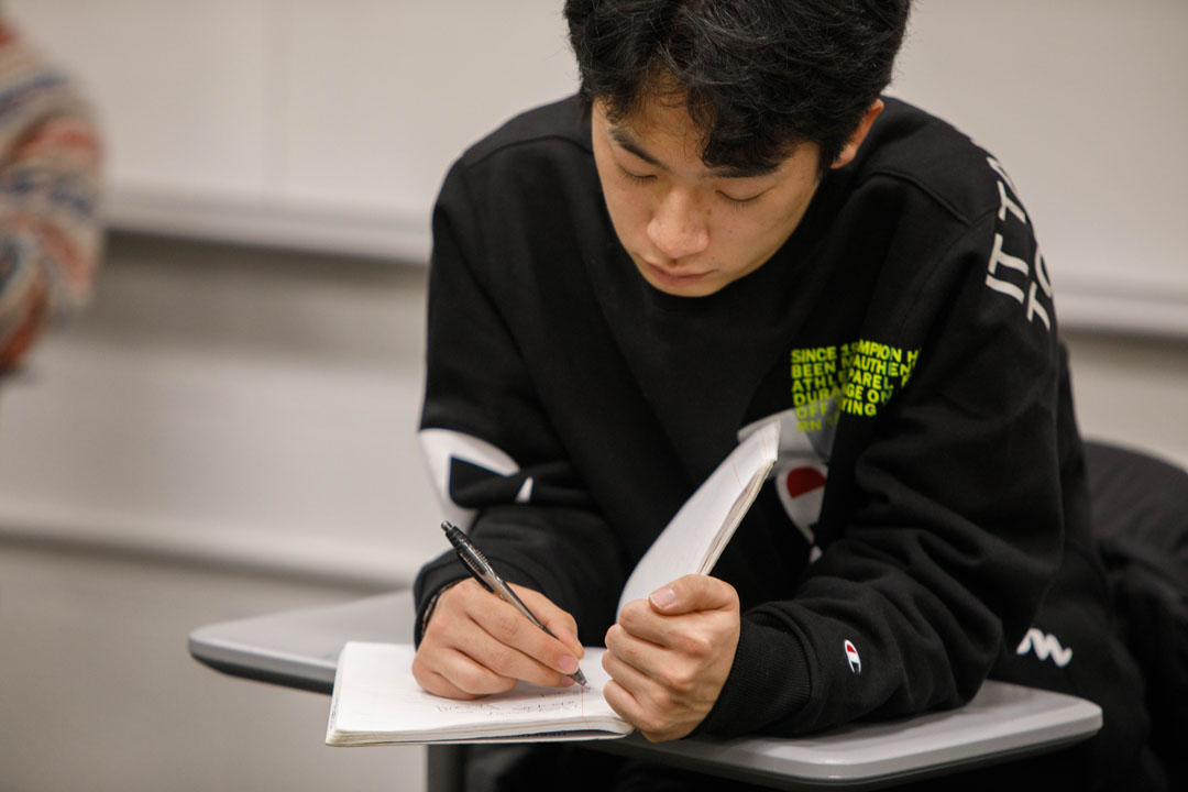 A student writing on a notepad