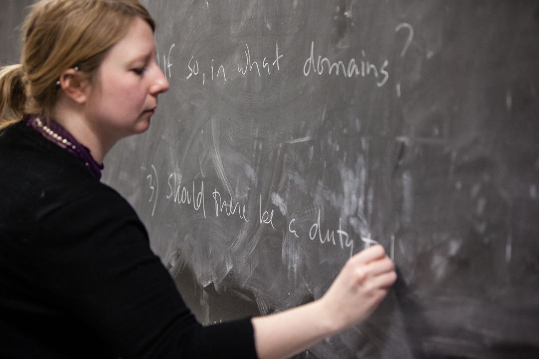 Professor Laura Papish writes on a black board