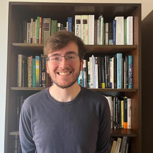 Sam Gass standing in front of a bookcase