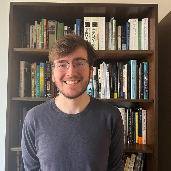 Sam Gass standing in front of a bookcase