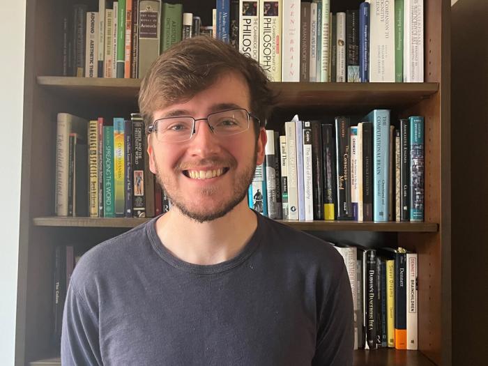 Sam Gass standing in front of a bookcase